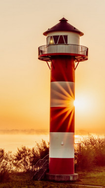 1026 Leuchtturm am Morgen mit Sonnenstern