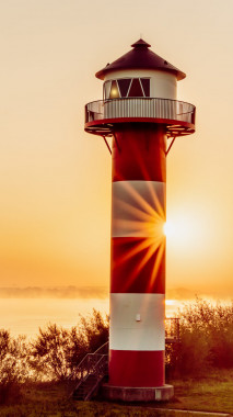 Nr.1026;  Leuchtturm am Morgen mit Sonnenstern